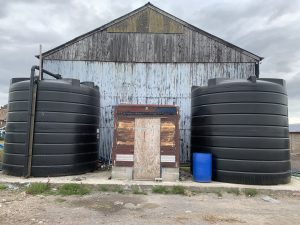A photo of the completed project with 2 water tanks and a control shed between them